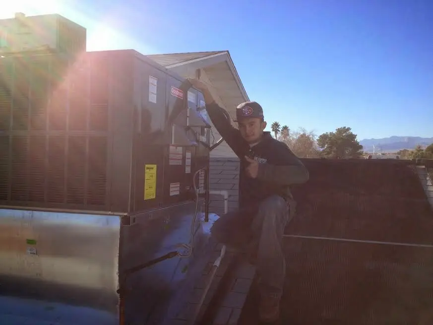 HVAC technician performing Heat Pump Repair on a rooftop unit in Vallejo